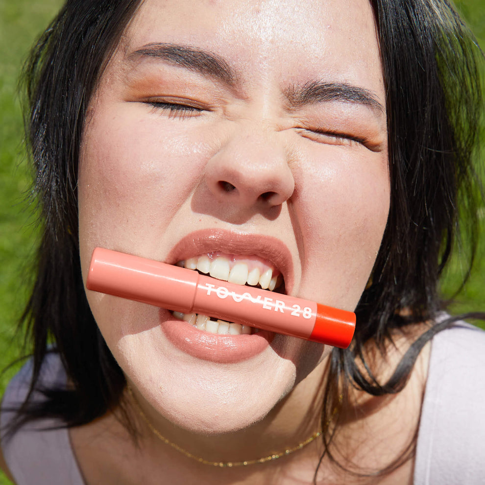 A model wearing Tower 28 Beauty's JuiceBalm Lip Balm in the shade Mix