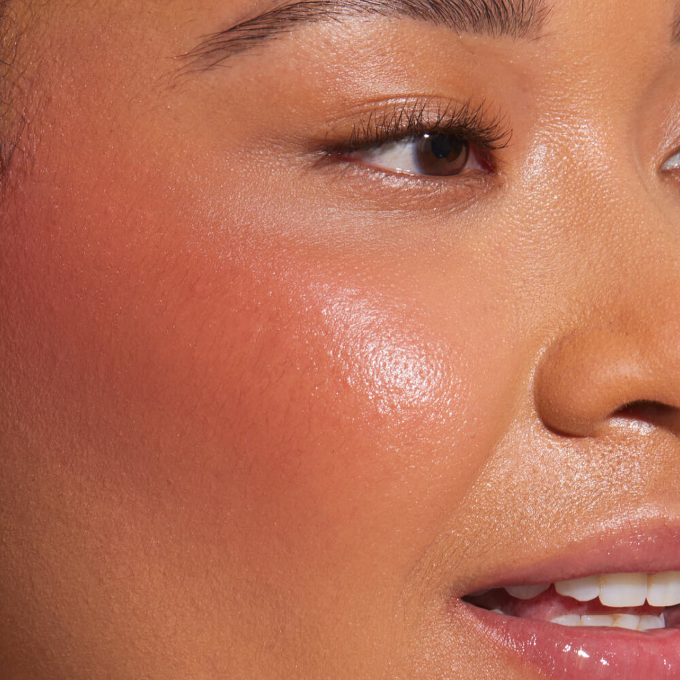 A close up of a model with Tower 28 Beauty's BeachPlease Cream Blush in Power Hour on her face.