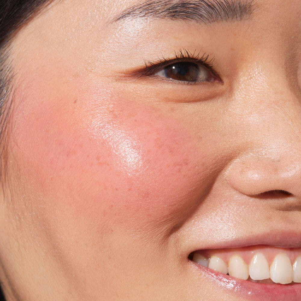 Office Hours [A close up of a model with Tower 28 Beauty's BeachPlease Cream Blush in Office Hours on her face.]