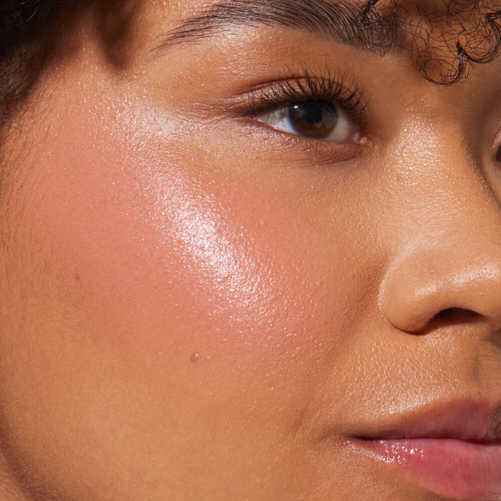 A close up of a model with Tower 28 Beauty's BeachPlease Cream Blush in Magic Hour on her face.