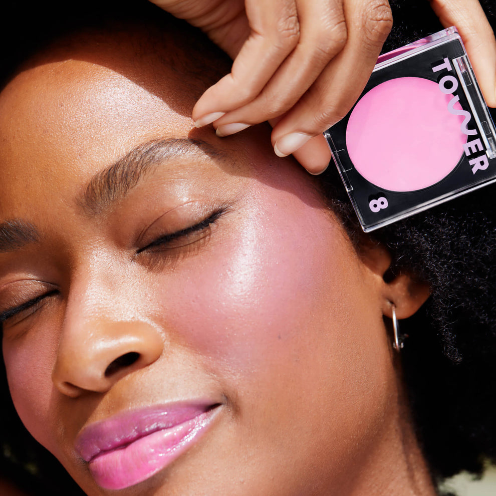 A close up of a model with Tower 28 Beauty's BeachPlease Cream Blush in Dream Hour on her face.