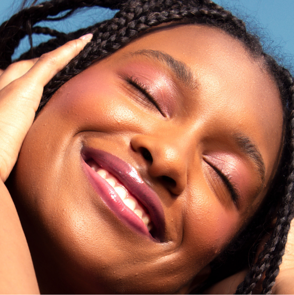 Closeup photo of a girl with very glossy lips, wearing the Tower 28 Beauty ShineOn Milky Lip Jelly shade in Sesame