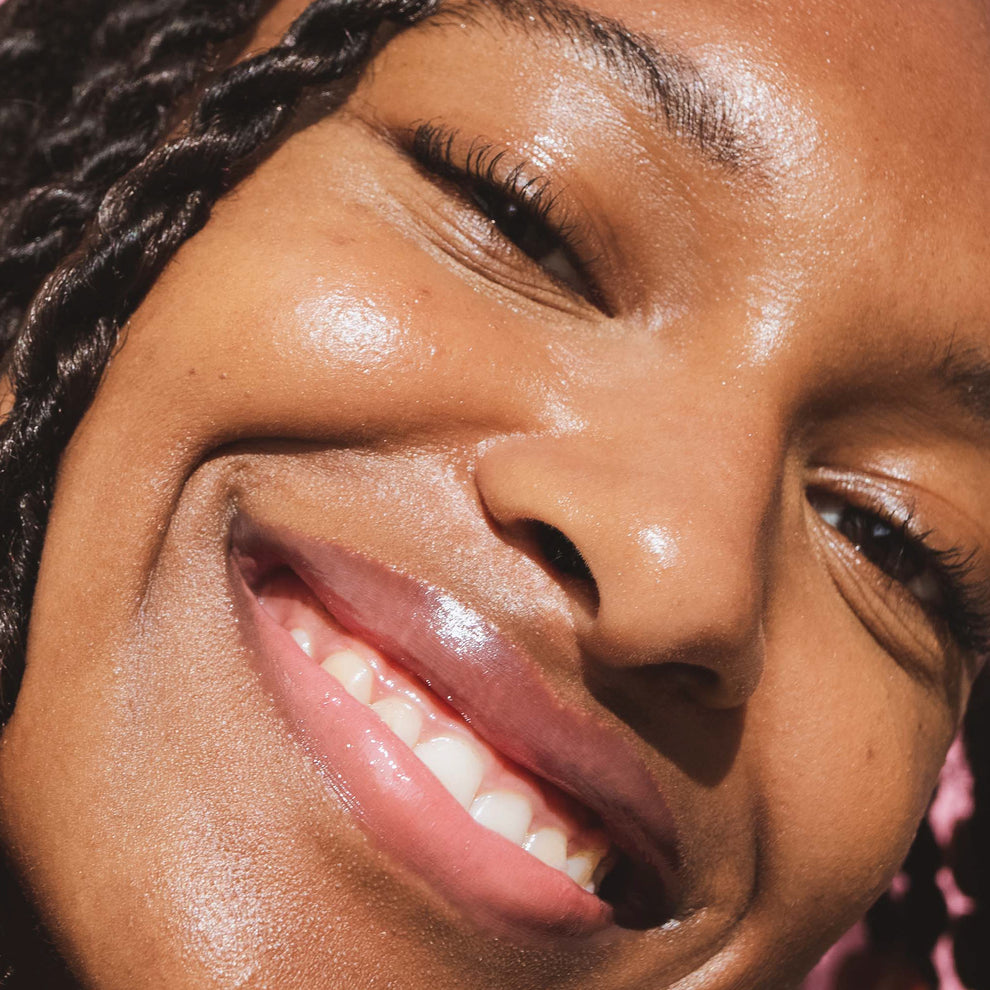 Closeup photo of a girl with very glossy lips, wearing the Tower 28 Beauty ShineOn Milky Lip Jelly shade in Pistachio