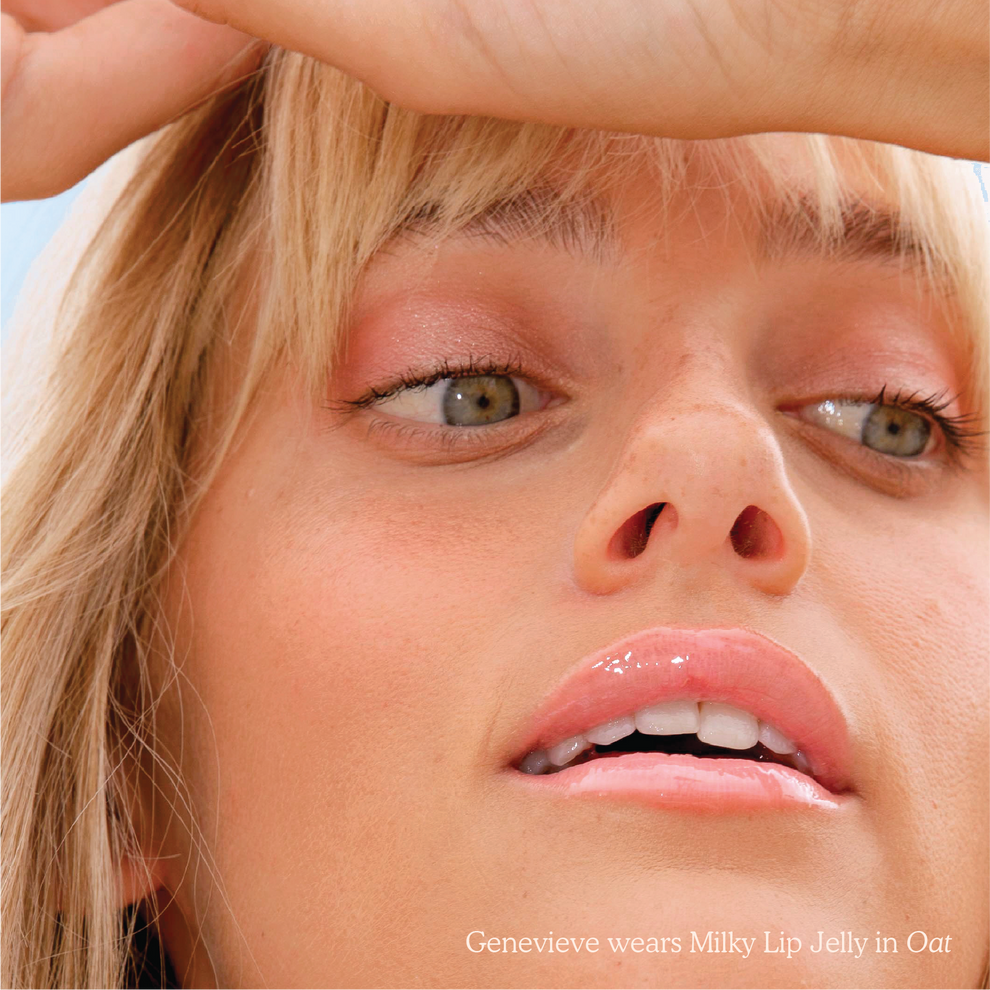 Closeup photo of a girl with very glossy lips, wearing the Tower 28 Beauty ShineOn Milky Lip Jelly shade in Oat (a milky peachy-pink)